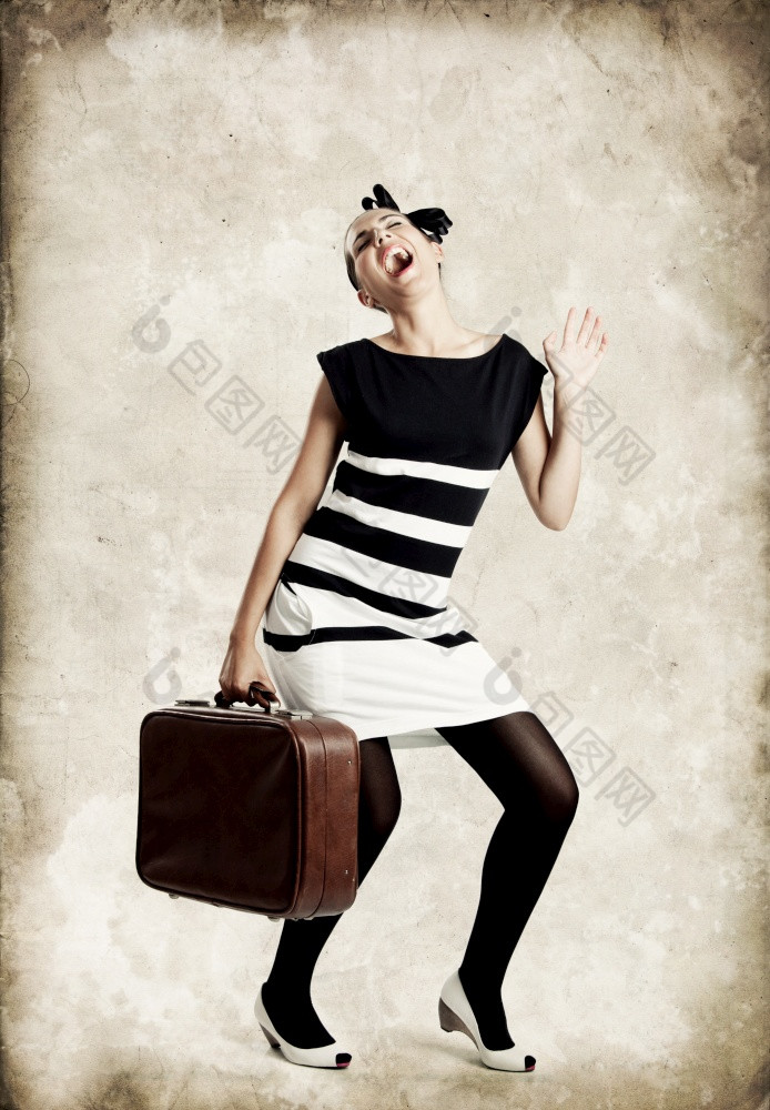 肖像美丽的时尚女人摆姿势和持有老手提箱