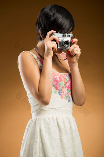 古董女孩采取图片使用老相机米色背景