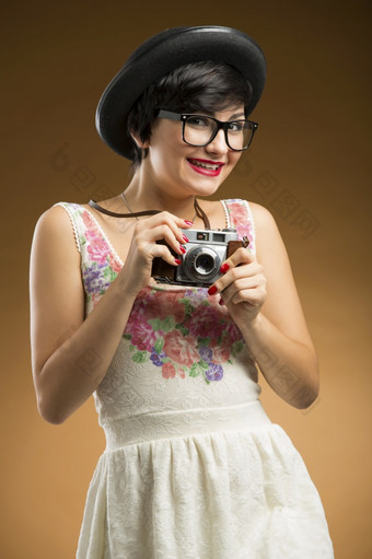 古董女孩采取图片使用老相机米色背景