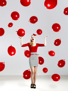 美丽的时尚女人红色的摆姿势与红色的气球