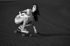 年轻的女人下来的路与滑板溜冰者女孩