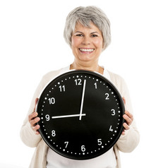 上了年纪的女人持有时钟isoalted白色背景