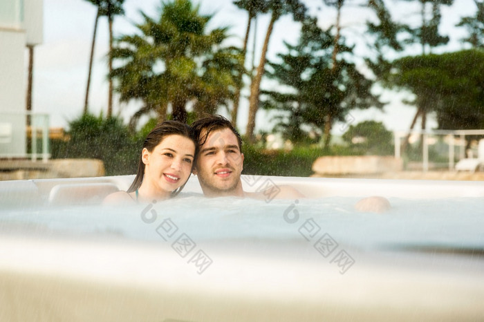 年轻的夫妇奢侈品酒店内部极可意水流按摩浴缸多雨的一天