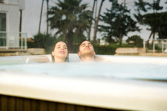 年轻的夫妇奢侈品酒店内部极可意<strong>水流</strong>按摩浴缸多雨的一天