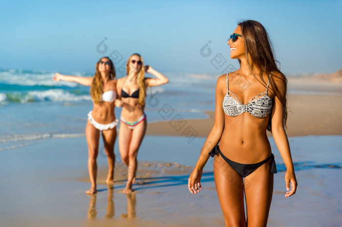 三个美丽的女孩有有趣的的海滩