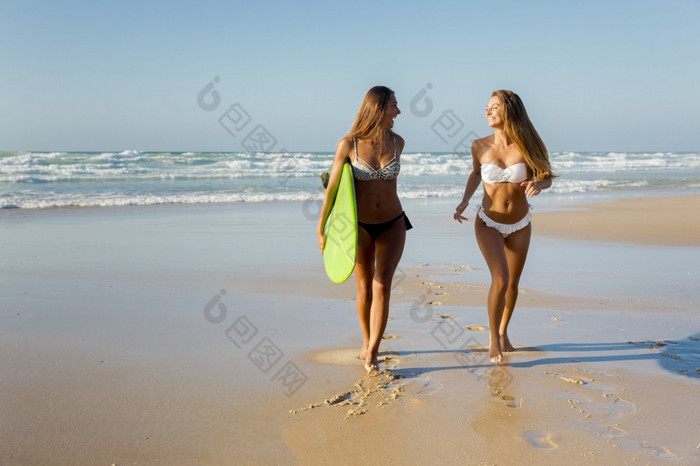 最好的朋友享受的夏天运行的海滩与冲浪板