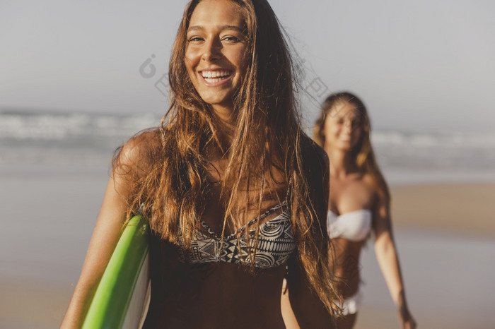 最好的朋友享受的夏天走的海滩与冲浪板