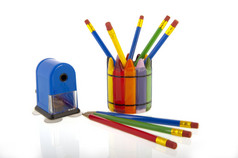 拼贴画多彩的色泽铅笔杯与蓝色的铅笔卷笔刀孤立的在白色背景