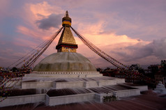 佛教神社布达哈纳特佛塔与祈祷旗帜在日落天空尼泊尔加德满都