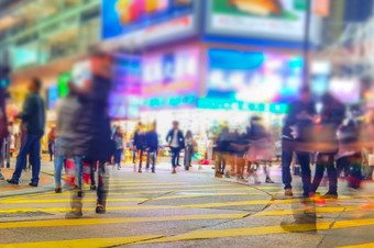 模糊图像人移动拥挤的晚上城市街与浑身湿透的购物中心在香港香港模糊效果