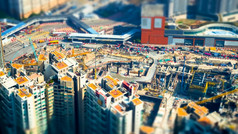 倾斜转变模糊效果令人惊异的空中城市景观视图与起重机工作建筑建设在香港香港摘要未来主义的城市景观与现代摩天大楼