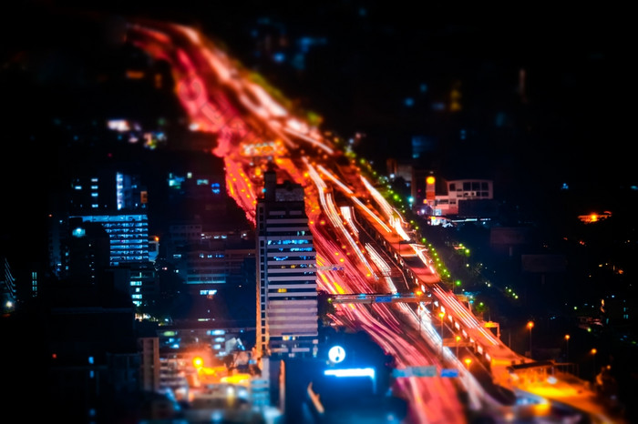 倾斜转变模糊效果未来主义的晚上城市景观空中视图全景与照亮摩天大楼和城市交通在街道曼谷泰国