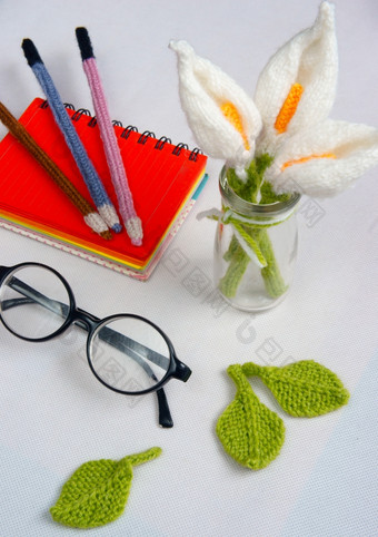 浪漫的桌子上与点缀从手工制作的产品莉莉花针织从白色纱手册针织铅笔咖啡杯眼镜美丽的工艺