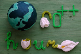 地球小时消息绿色背景为特殊的一天一天提醒人给手保存的地球绿色信与白色花象征为转从光一分钟