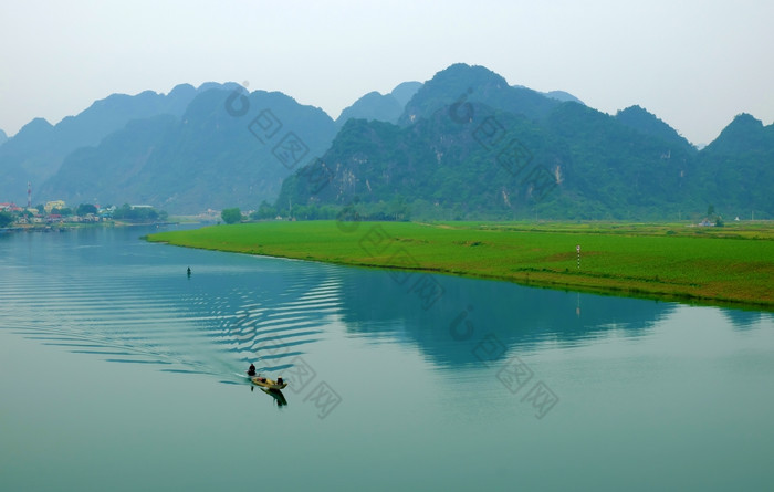 令人惊异的自然景观被兵越南南一天船移动河河畔房子与山后面绿色场旁边水美丽的场景为越南旅行