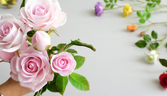 美妙的粘土艺术女人手持有花束<strong>玫瑰</strong>花粉红色的白色背景美丽的人工花工艺与熟练的