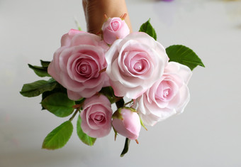 美妙的粘土艺术女人手持有花束玫瑰花粉红色的白色背景美丽的人工花工艺与熟练的