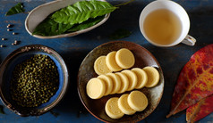 越南甜蜜的食物绿色豆子蛋糕从绿色小扁豆传统的食物为茶时间板食物杯茶木背景