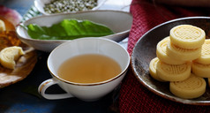 越南甜蜜的食物绿色豆子蛋糕从绿色小扁豆传统的食物为茶时间板食物杯茶木背景