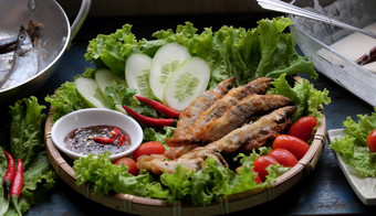 <strong>越南</strong>食物为家庭餐午餐晚餐炸鱼与罗望子酱汁和绿色蔬菜美味的食物自制的木背景