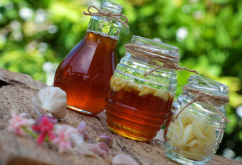 健康的食物从自然Herbal大蒜浸泡蜜蜂蜂蜜草补救措施为皮肤哪医疗保健三个Jar绿色背景