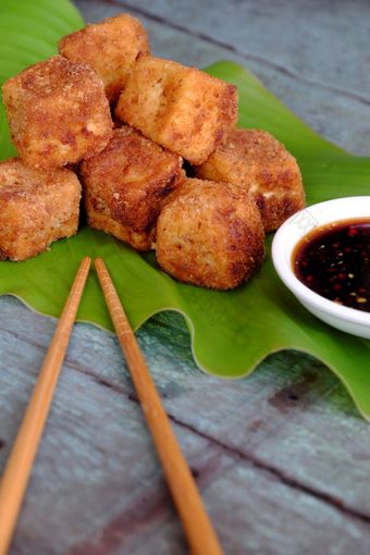 节俭的素食者食物从越南厨房炸豆腐与香料权力封面与脆皮面粉自制的食物绿色叶背景大豆酱汁为素食主义者