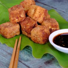 节俭的素食者食物从越南厨房炸豆腐与香料权力封面与脆皮面粉自制的食物绿色叶背景大豆酱汁为素食主义者