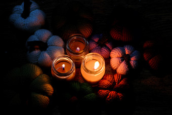 美丽的针织南瓜从纱与<strong>三个</strong>蜡烛晚上蜡烛光使色彩斑斓的背景不错的手工制作的<strong>产品</strong>从休闲活动