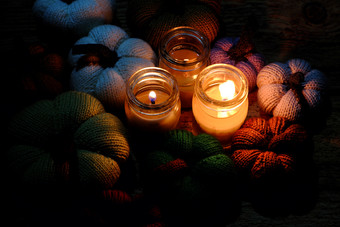 美丽的针织南瓜从纱与<strong>三个</strong>蜡烛晚上蜡烛光使色彩斑斓的背景不错的手工制作的<strong>产品</strong>从休闲活动