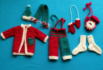 前视图圣诞老人衣服与配件手套他围巾袜子白色红色的和绿色针织从纱蓝色的背景小装饰为圣诞节季节冬天假期