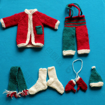 前视图圣诞老人衣服与配件<strong>手套</strong>他围巾袜子白色<strong>红色</strong>的和绿色针织从纱蓝色的背景小装饰为圣诞节季节冬天假期