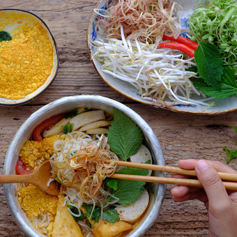 前视图人吃碗自制的素食主义者rieu面条汤素食者蟹粘贴粉丝汤传统的越南菜板蔬菜草本植物准备好了吃木背景