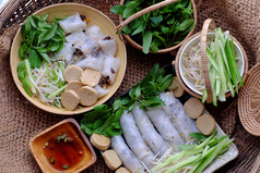 前视图自制的越南素食者滚蒸大米煎饼球cuon两个板与篮子草和酱汁粗麻布背景