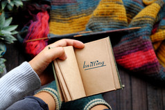 前视图女人脚与袜子坐着阳台手持有卡夫纸笔记本与针织写作使色彩斑斓的围巾为有意义的冬天礼物
