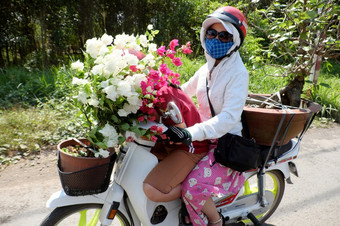 <strong>越南女人</strong>穿脸面具眼镜头盔骑摩托车移动国家路运输花能中午影子反映表面路盾奈<strong>越南</strong>