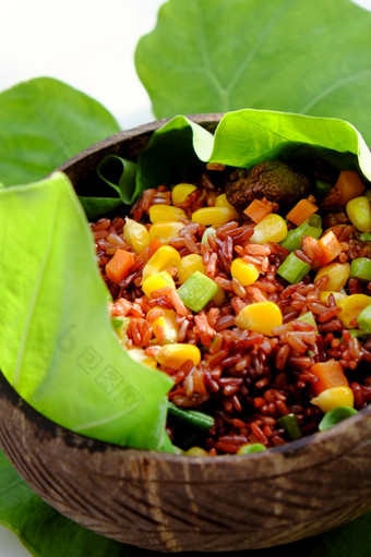 越南厨房从红色的大米美味的和营养大米菜为午餐自制的食物丰富的有营养的椰子壳牌碗与芝麻盐绿色叶背景
