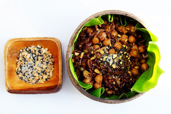越南厨房从红色的大米美味的和营养大米菜为午餐自制的食物丰富的有营养的椰子壳牌碗与芝麻盐绿色叶背景