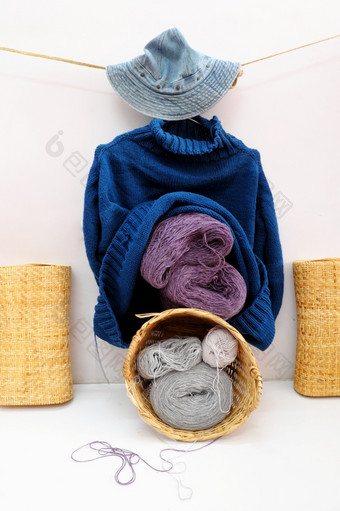 手工制作的产品为冬天季节礼物球纱材料针织竹子篮子男人。蓝色的毛衣挂白色背景手工艺与羊毛衣服冷季节年越南