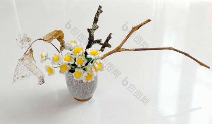 黛西花瓶为首页装饰花能Diy回收脸面具与白色水泥用钩针编织小白色花与黄色的雄蕊和干分支树白色背景