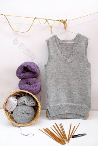 手工制作的产品使礼物为冬天季节球纱材料为针织和男人。背心灰色挂白色背景手工艺与羊毛衣服冷季节年越南