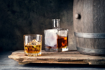 玻璃威士忌与冰玻璃水瓶和桶木表格玻璃威士忌与冰玻璃水瓶和桶