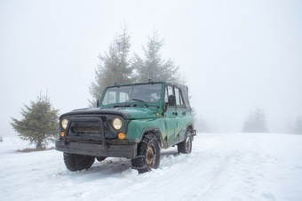 绿色越野车辆的白雪覆盖的山雾绿色越野车辆的白雪覆盖的山