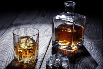 老威士忌玻璃和玻璃水瓶木表格老威士忌玻璃和玻璃水瓶
