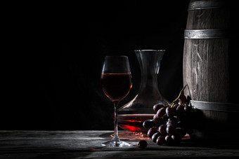 玻璃红色的酒玻璃水瓶和桶黑暗背景玻璃红色的酒玻璃水瓶和巴利