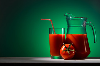 番茄汁玻璃和壶绿色背景番茄汁玻璃和壶