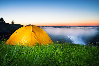 照亮从在橙色帐篷山以上有雾的河早期早....的概念新一天和自由照亮从在橙色帐篷hil