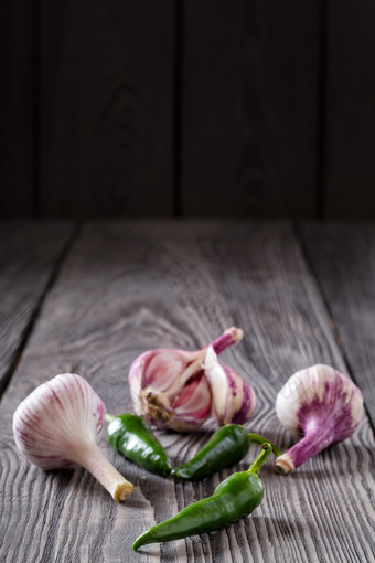 大蒜和辣的绿色胡椒木表格香料调味品的概念自然食物和丰富的收获大蒜和辣的绿色胡椒木表格