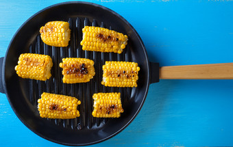 烤玉米煎锅蓝色的背景视图从以上的概念健康的自然食物烤玉米煎锅