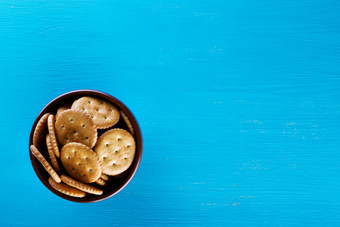 碗与脆皮饼干蓝色的背景视图从以上的概念健康的饮食碗与脆皮饼干蓝色的背景