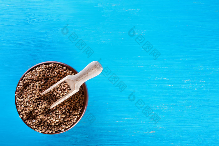 粘土棕色（的）板与生荞麦蓝色的背景视图从以上的概念健康的自然食物粘土棕色（的）板与生荞麦蓝色的背景